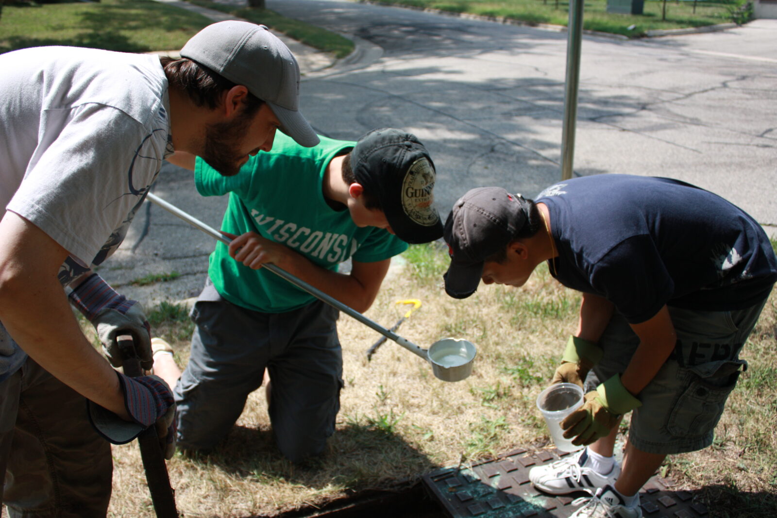 picture of 3 individuals dipping for mosquito larvae